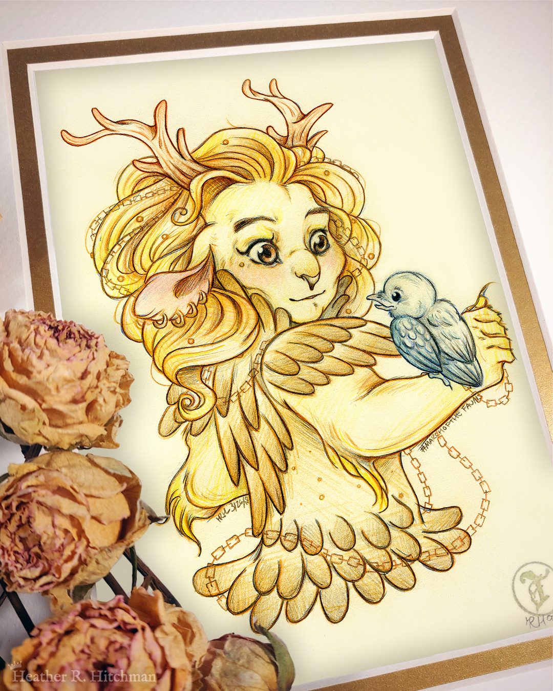 Photograph of a matted print of a graphite and colored pencil hips up portrait drawing of a child female faun with golden fur, orange eyes, and branch like antlers. The faun is wearing golden armor that looks like feathers, and has copper chains woven through her golden mane that flow around her body. She has four gold hoop piercings in her right ear, and a tiny golden stud piercing below the outside corner of her right eye. The faun stands with her back to the viewer, looking over her right shoulder at a small raven hatchling that stands on her right arm. The raven looks up at the faun with a happy expression. The faun looks back at the raven with a subdued pleasantly surprised expression. The faun child looks youthful, and yet has undeniable strong bone structure that makes her look somewhat like a lioness in the face. The mat-board is white on the top layer and gold on the second layer. Orange roses rest on top of the print to the left. A small gold stamp with the Terratoff icon is at the bottom right corner of the print.