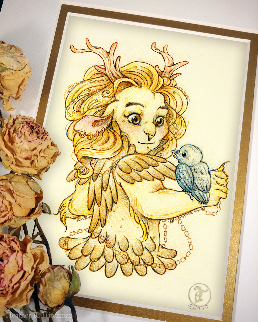 Photograph of a matted print of a graphite and colored pencil hips up portrait drawing of a child female faun with golden fur, orange eyes, and branch like antlers. The faun is wearing golden armor that looks like feathers, and has copper chains woven through her golden mane that flow around her body. She has four gold hoop piercings in her right ear, and a tiny golden stud piercing below the outside corner of her right eye. The faun stands with her back to the viewer, looking over her right shoulder at a small raven hatchling that stands on her right arm. The raven looks up at the faun with a happy expression. The faun looks back at the raven with a subdued pleasantly surprised expression. The faun child looks youthful, and yet has undeniable strong bone structure that makes her look somewhat like a lioness in the face. The mat-board is white on the top layer and gold on the second layer. Yellow roses rest on top of the print to the left. A small gold stamp with the Terratoff icon is at the bottom right corner of the print.