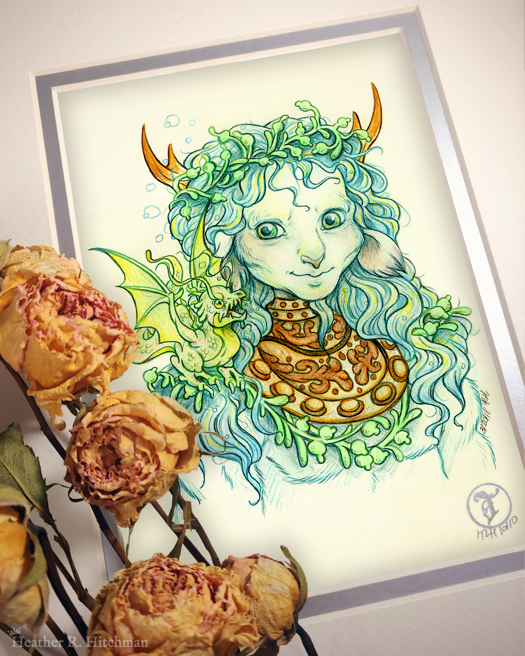 Photograph of a matted print of a graphite and colored pencil chest up portrait drawing of a male faun with teal hair and small pointed wood antlers. The faun is facing ¾ to the right and wears the copper collar of an old diving helmet around his neck like a necklace. His long wavy hair looks wet and has strands of green seaweed entangled around his crown and chest. The faun’s build is muscular yet lean, with defined cheekbones and striking green eyes. The faun is looking over to the left with a smirk on his face towards a small green water dragon perched on his shoulder. The water dragon is lifting it’s wings into the air with excitement looking back at the faun. The mat-board is white on the top layer and silver on the second layer. Yellow roses rest on top of the print to the left. A small silver stamp with the Terratoff icon is at the bottom right corner of the print.