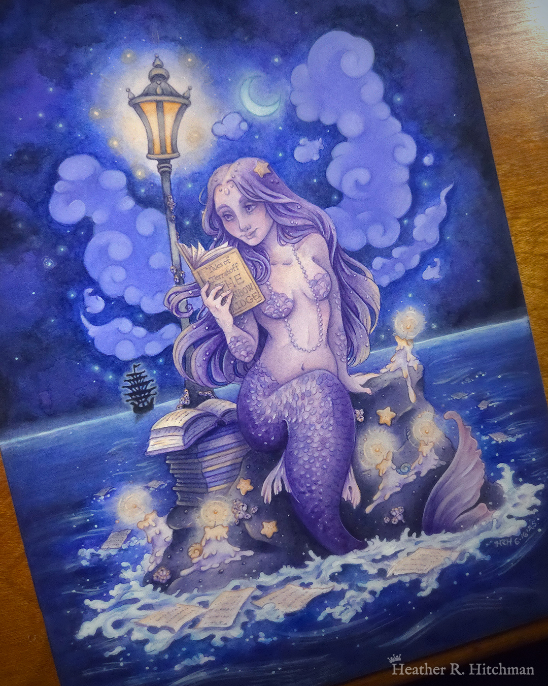 Watercolor and gouache full body painting of a purple mermaid reading a book under the moonlight while sitting on a gray rock in the middle of the sea. The rock is covered in glowing candles and also has a pile of books besides the mermaid’s tail. An old fashioned street lantern covered in barnacles is attached to the rock, illuminating orange light against a dark blue night sky. Gentle blue waves wash up against the rock. Loose white pages from books float in the water into the distance, leading towards a mysterious black ship that vanishes into the night. Puffy light blue fish shaped clouds fill the nigh sky surrounding a crescent moon. The mermaid is holding a book in her right hand up to her face. Her other hand is placed behind her as she leans back slightly, her left arm supporting her weight. Her body faces the viewer, and she has a peaceful smile as she looks towards the book and reads.