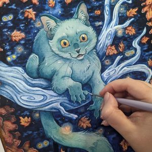 Photograph of a watercolor and gouache painting print of a spooky teal green cat lounging on a light blue branch in a spooky autumn forest at night. Orange red leaves frame the foreground, while a dark blue forest of trees and haunting glowing yellow eyes are behind the cat. A tiny crescent moon is visible between the background trees in the far distance. The cat is leaning forward over the branch, it’s yellow eyes piercing towards the viewer with a mischievous expression. The hand of the artist is holding a small paintbrush with white paint, embellishing the highlights in the cat’s fur. Sections of the rest of the print have already been embellished with small silver painted stars and golden orbs. A few small opal and orange flat back crystals embellish the night sky.