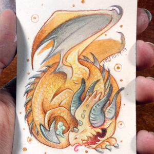 Photograph of a hand holding a small watercolor and gouache painting of a yellow baby dragon with gray spikes down it’s back. The dragon’s body is coiled into a circular shape, with it’s barbed tail resting against the face. The dragons wings are lifted upwards showing off its golden scales. The dragon has two sets of gray horns, one of which are protruding out of its eye sockets in place of eyeballs. The blind dragon has a happy devilish open mouth grin on his face as he sticks out his tongue.