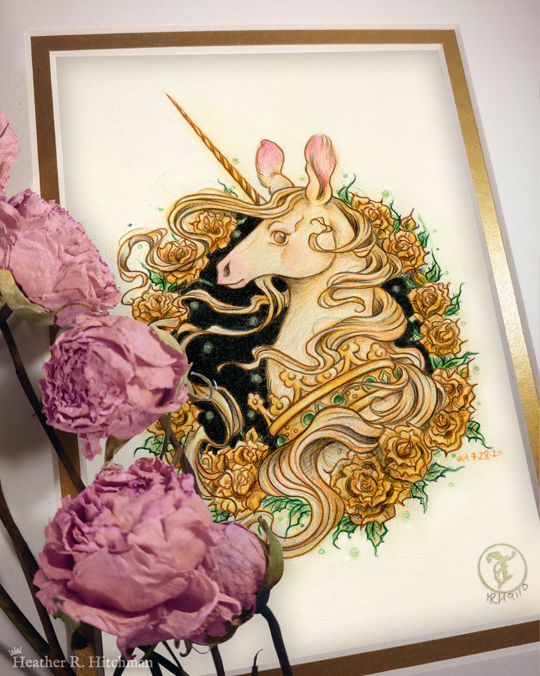 Photograph of a matted print of a graphite and colored pencil portrait drawing of a light gold colored royal unicorn bust framed in a circular wreath of golden roses. The background inside of the wreath behind the unicorn is black with tiny orbs of green light floating around. Outside of the wreath the portrait has a sepia background color. The unicorn lifts her head in profile facing to the left with a peaceful expression on her face. He has a flowing gold and pink mane and chin beard, light golden fur, and a long golden horn in the center of her forehead. The unicorn wears a large crown of green jewels around her neck. Pink roses rest on top of the print to the left. A small gold stamp with the Terratoff icon is at the bottom right corner of the print.