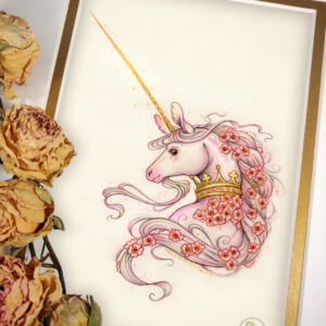 Photograph of a matted print of a graphite and colored pencil portrait drawing of a unicorn bust celebrating the Swift Coronation. The unicorn is visible from the shoulders up, with her back facing the viewer and her head looking over the left shoulder with a peaceful expression. The unicorn’s coat is a mix of soft white and pink tones, with soft pink on her ear tips and muzzle. She has a very long golden horn, longer than average ears, and wears a golden crown encrusted with rubies around her neck. Her long mane is decorated with red anemone flowers, a large portion of them are concentrated towards the bottom right of the crown. The mat-board is white on the top layer and gold on the second layer. Yellow roses rest on top of the print to the left. A small golden stamp with the Terratoff icon is at the bottom right corner of the print.