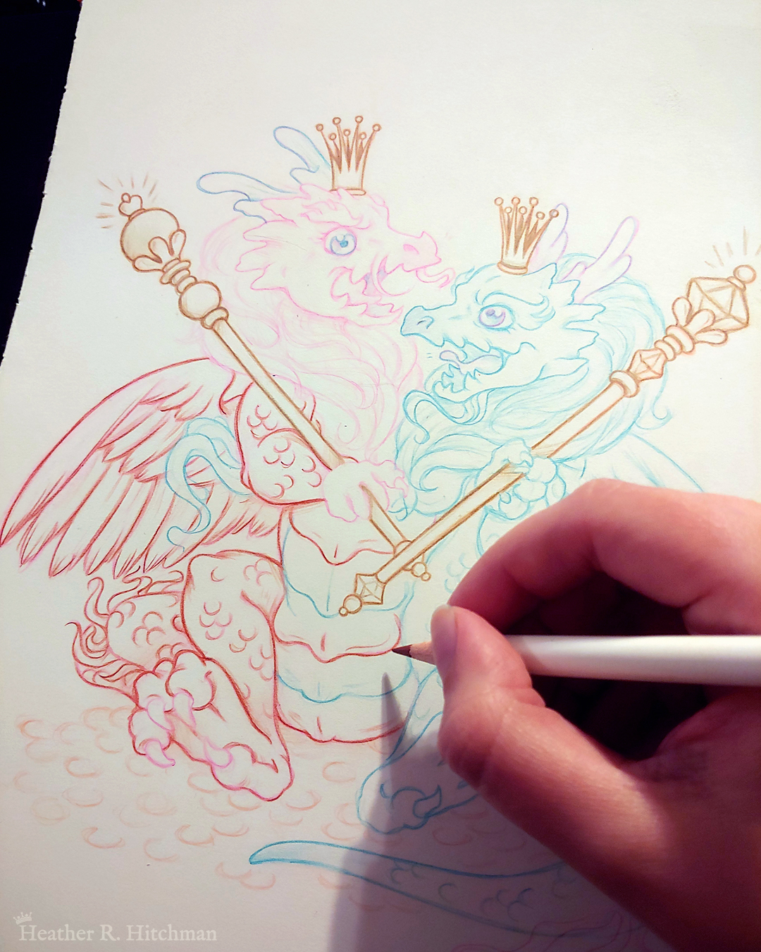 Close up process photograph of a colored pencil and graphite drawing of a baby 2 headed hydra dragon. The left head and side of the dragon is red, the right head and side of the dragon is blue. The hydra sits upright on its butt facing the front on top of a pile of golden coins. The hind legs are spread forward while each arm holds a golden scepter in it’s claws. The two heads are arguing over the gold and treasure the hydra sits upon. Each head wears a golden crown on their head. The red head on the left has an angry roaring expression. The blue head on the right smiles mockingly. The hydra has a set of feathered wings like a bird, the left wing red and the right wing blue. The hand of the artist is to the right holding a pencil over the image. Various sections of the drawing look more rendered than others.