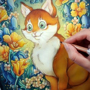 Close up watercolor, gouache, and colored pencil portrait painting of an orange cat sitting in a garden. The painting is currently being painted by the artist, who’s hand is in the middle right edge of the photograph holding a colored pencil near the cat’s chest. The photograph focuses on the cat’s face. The cat sits upright at a ¾ angle on the grass, facing to the left with a wide eyed happy expression on his face. His tail is coiled around in front of his feet. He has bright green eyes, white fur around his eyes and on his chest, and rich golden orange fur on the rest of his body. An archway of bluebells, yellow California poppies, and small white flowers surround the cat in an enchanted garden scene. The background is dark teal green with a sunburst of yellow light coming from behind the cat. Small golden orbs of light surround the scene.