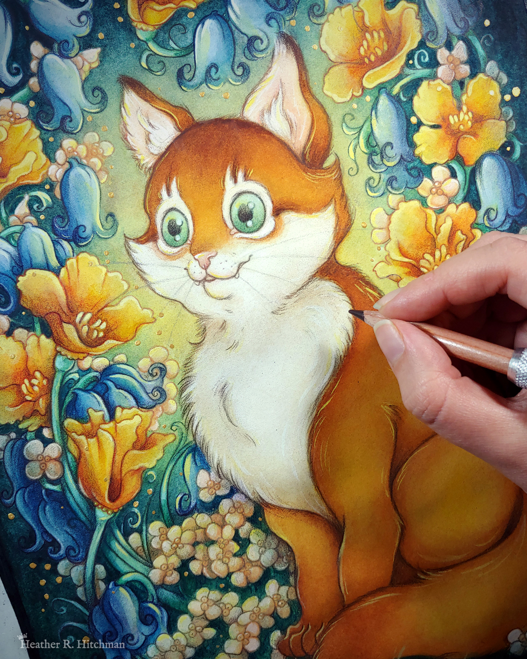 Close up watercolor, gouache, and colored pencil portrait painting of an orange cat sitting in a garden. The painting is currently being painted by the artist, who’s hand is in the middle right edge of the photograph holding a colored pencil near the cat’s chest. The photograph focuses on the cat’s face. The cat sits upright at a ¾ angle on the grass, facing to the left with a wide eyed happy expression on his face. His tail is coiled around in front of his feet. He has bright green eyes, white fur around his eyes and on his chest, and rich golden orange fur on the rest of his body. An archway of bluebells, yellow California poppies, and small white flowers surround the cat in an enchanted garden scene. The background is dark teal green with a sunburst of yellow light coming from behind the cat. Small golden orbs of light surround the scene.
