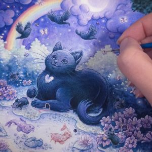 Closeup photograph of a print of a watercolor, gouache and colored pencil full body painting of a black cat sitting in a fantasy moonlit garden. The scene depicts a purple and blue night sky with a white crescent moon nestled within a large purple cloud. A moonbow is arching across the sky from the moon towards the ground. The black cat looks up with an enchanted expression at three black birds flying joyfully overhead. The cat’s fur has subtle highlights of purple and blue, and she has a white tuft of fur on her chest shaped like a heart. The cat is sitting at a ¾ angle facing to the left and is holding a long rainbow tail of a black mouse in her right paw. In front of the cat is a small pond that has purple water lilies, 3 koi fish, and the reflection of the moonbow. Surrounding the pond more black mice with rainbow tails run and play among lilac colored cosmos flowers. Behind the cat is a hedge of blueish green bushes that stretch the length of the scene. In the foreground a black tree branch overhangs the top corner on each side. The fingertips of the artist are on the top right of the photograph, holding a tiny paintbrush that she is using to embellish the environment of the print with silver orbs of light. Several purple flat back crystals decorate the waters of the pond and the stars in the night sky.
