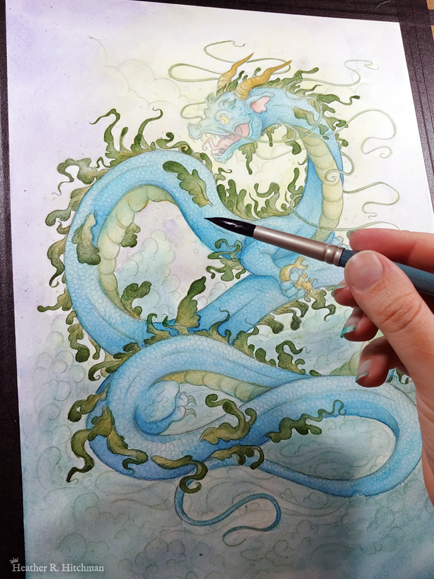 Photograph of a watercolor, gouache, and colored pencil painting in progress of a gigantic water dragon sitting atop a sea of foaming waves out in the ocean. So far the lines of the painting are sketched in, with pastel greens and blues painted in faintly on the dragon. The fingertips of the artist holds a watercolor brush to the right of the painting. The sky behind the dragon has moody clouds sketched in. The dragon has a long snakelike body covered in blue scales. Green frills of fins run down the length of the dragon’s back, and several more fins appear along its sides. The dragon has no wings, instead presenting like a classic eastern style dragon with long white whiskers, golden horns, front legs at the chest, and stumpy back legs towards the end of his long tail. The dragon’s body coils in a ribbon like shape, with its head upright and facing to the left. In it’s claws the dragon clutches a mer-bull that struggles to escape. The dragon’s face is menacing and mystical, with a hungry wicked smile showcasing his fangs and a giant pink tongue. The photograph is taken at an angle, and the painting is taped with black artist’s tape to a wooden surface.